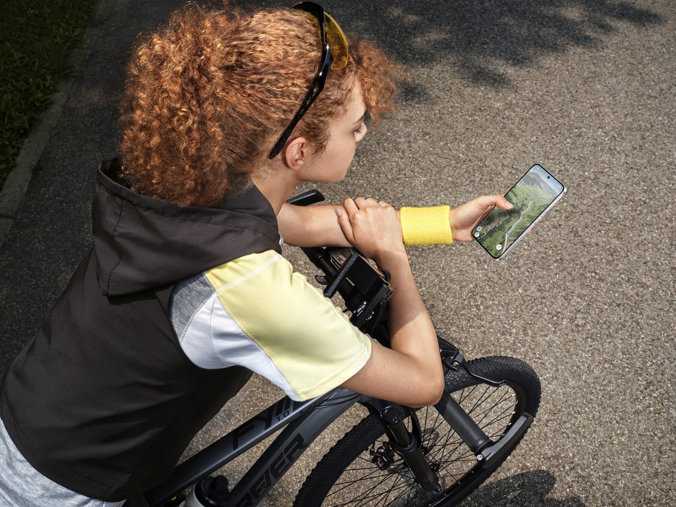 Cyclist using the POCO X8 outdoors to view its 120Hz AMOLED display